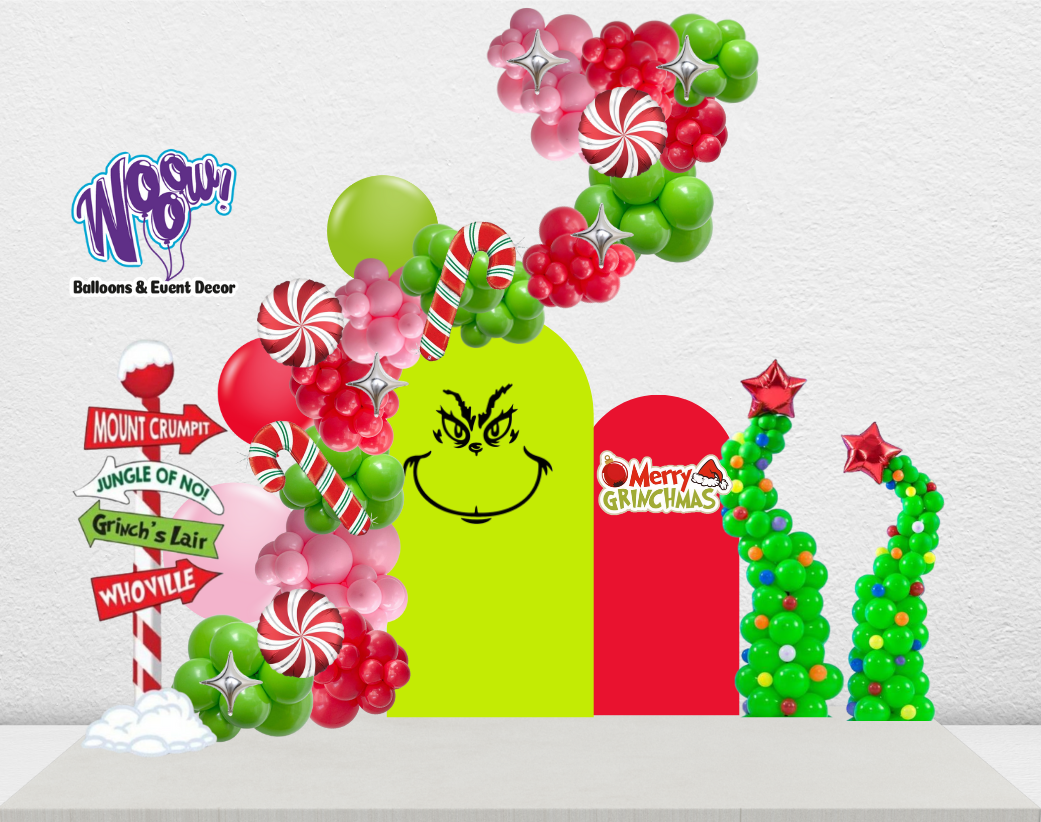 Grinch Decor Setup with balloon garlands, 3D backdrop, and Grinch-themed signs