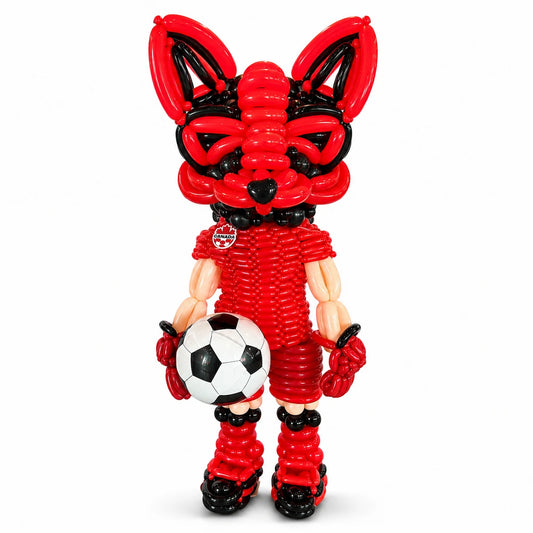 Custom fox balloon sculpture created for Tipsy Fox, wearing a Canada soccer uniform and holding a soccer ball.