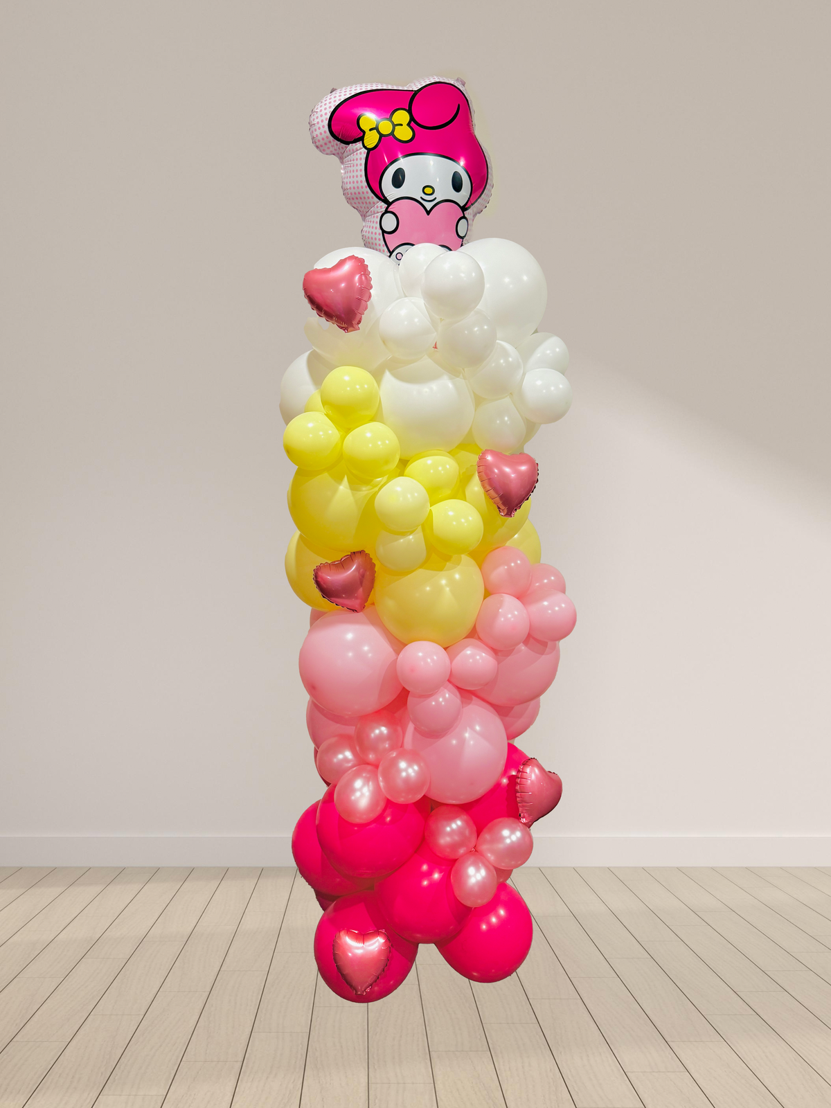 Balloon sculpture with a character on top against a plain background