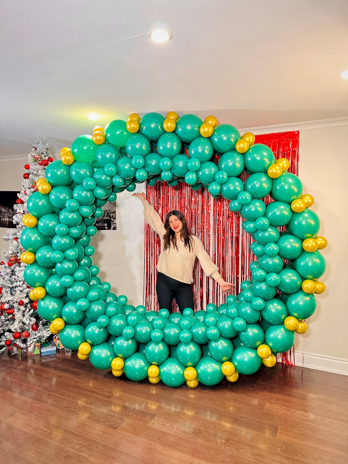Giant Christmas Balloon Wreath made with biodegradable balloons, customizable design, 10ft size with a red or gold bow.