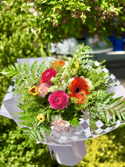 Bouquet of flowers with greenery and purple wrapping paper made by wooow balloons for mother's day