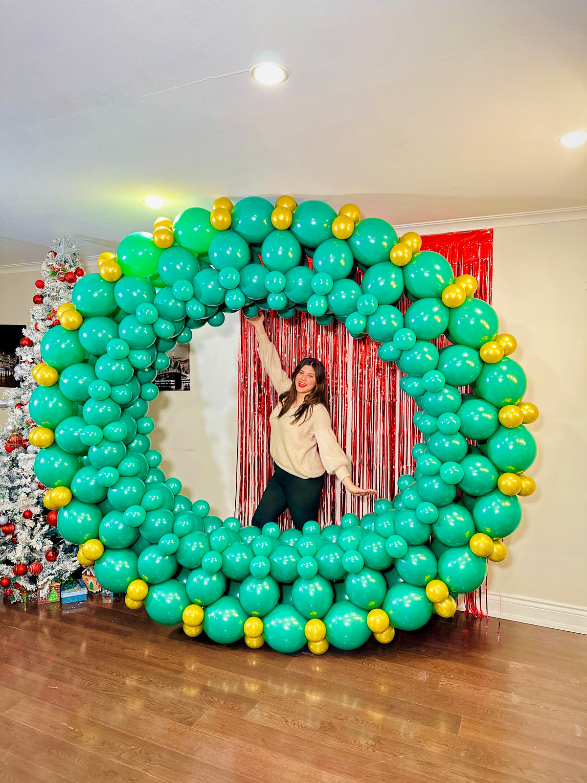 Giant Christmas Balloon Wreath made with biodegradable balloons, customizable design, 10ft size with a red or gold bow.