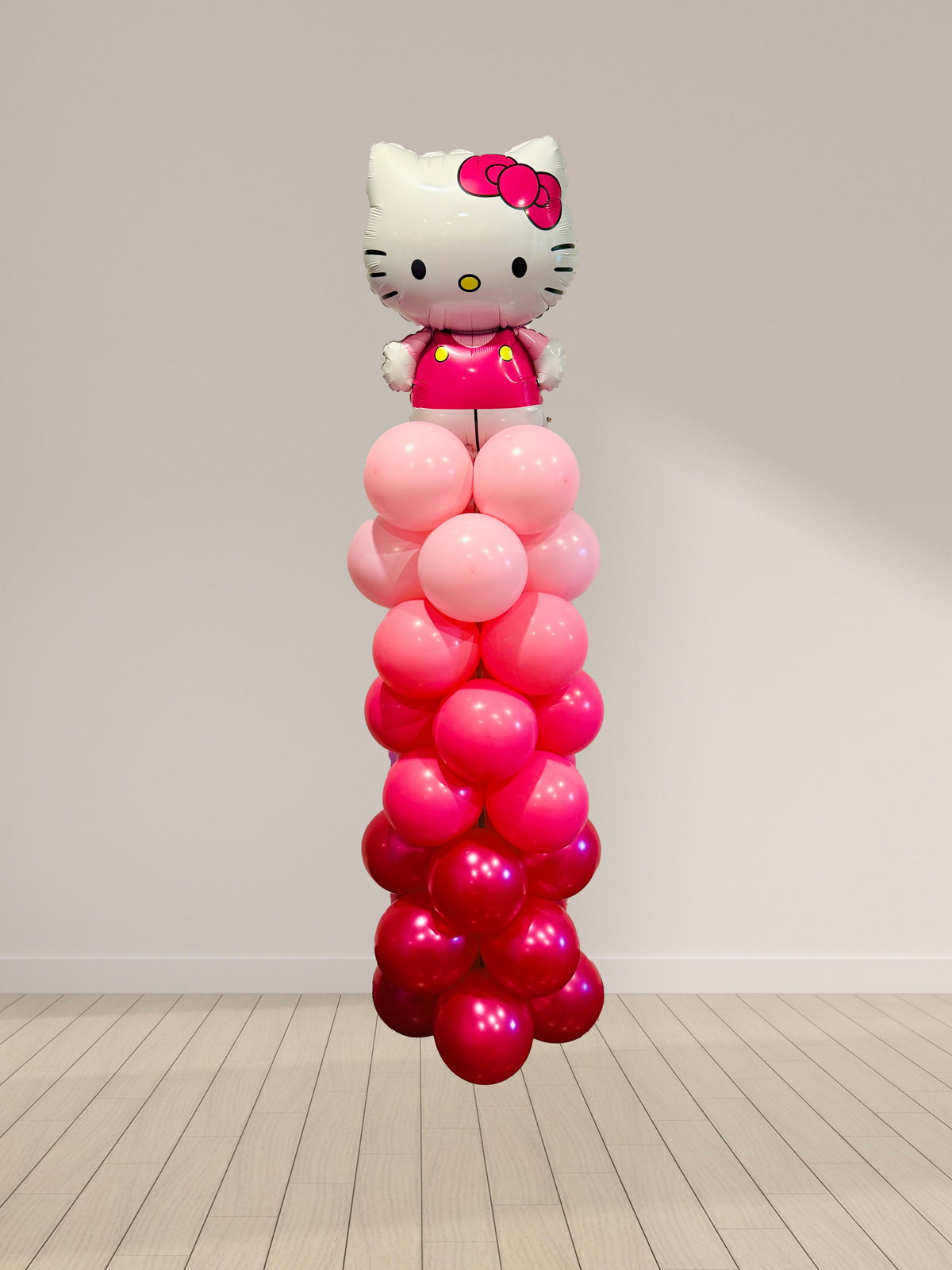 Balloon column with Hello Kitty figure against a plain background