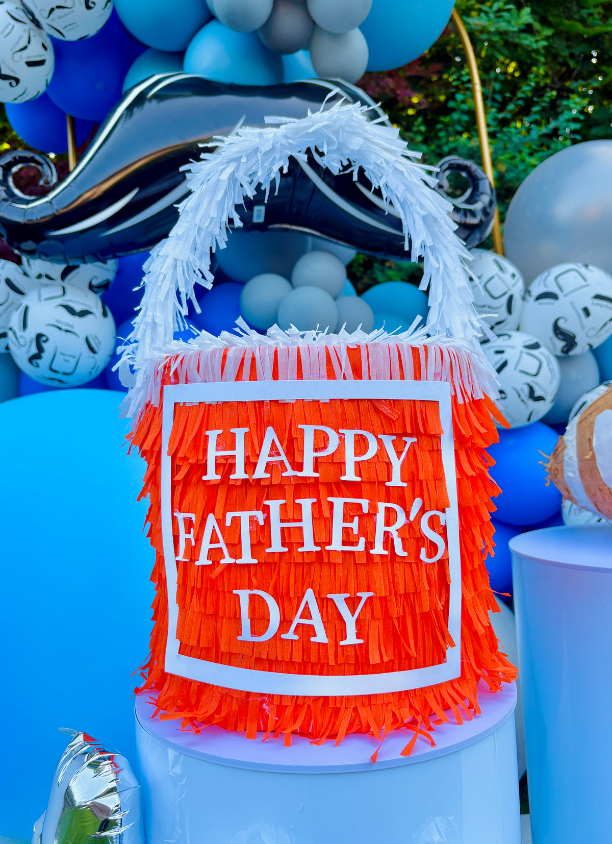 Decorative sign with 'Happy Father's Day' on an inflatable chair surrounded by balloons.