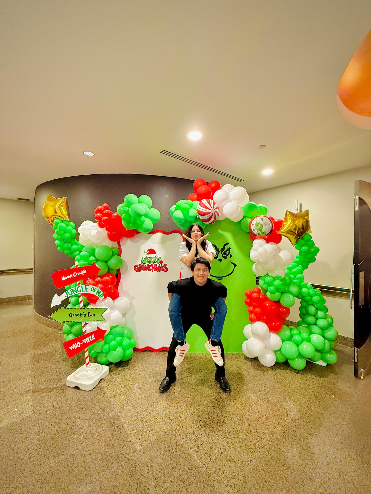 Grinch balloon decor setup with festive balloon garlands and backdrops.

