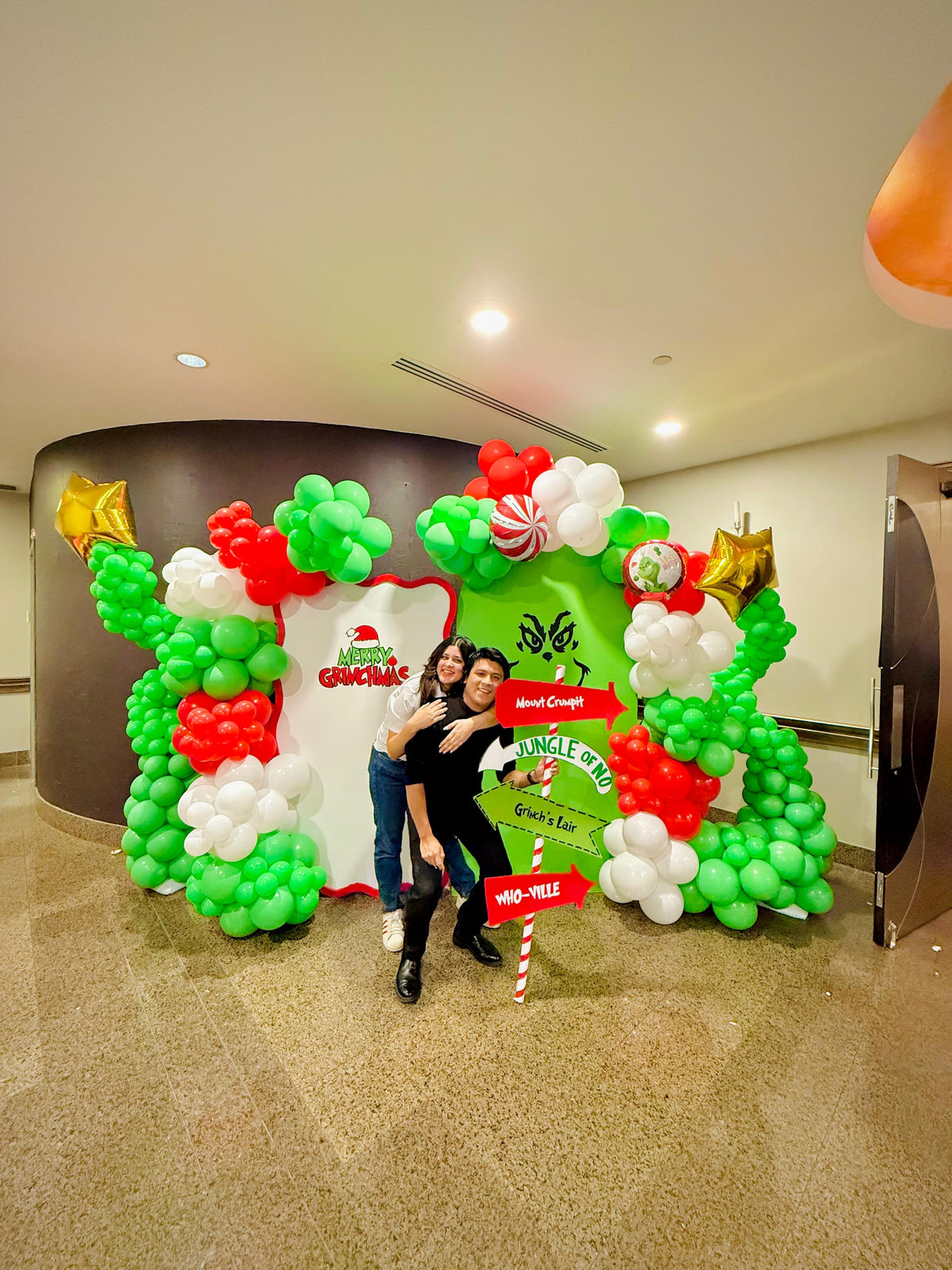 Grinch balloon decor setup with festive balloon garlands and backdrops.

