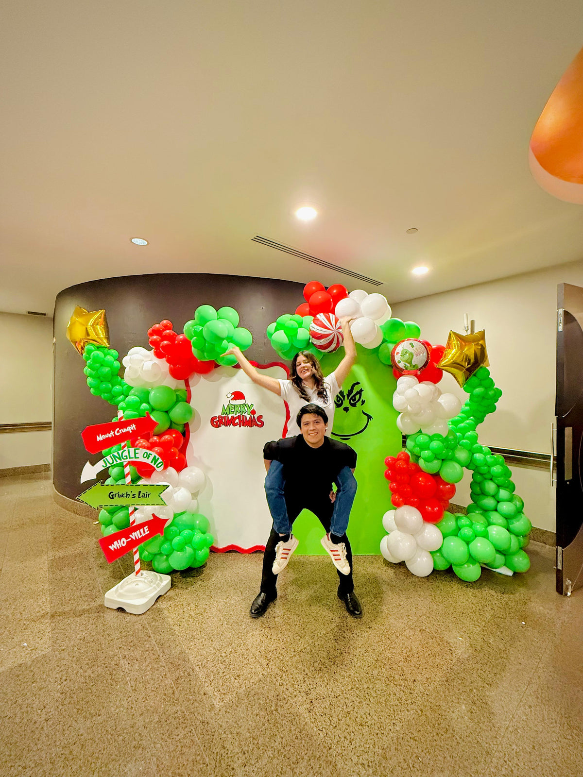 Grinch balloon decor setup with festive balloon garlands and backdrops.

