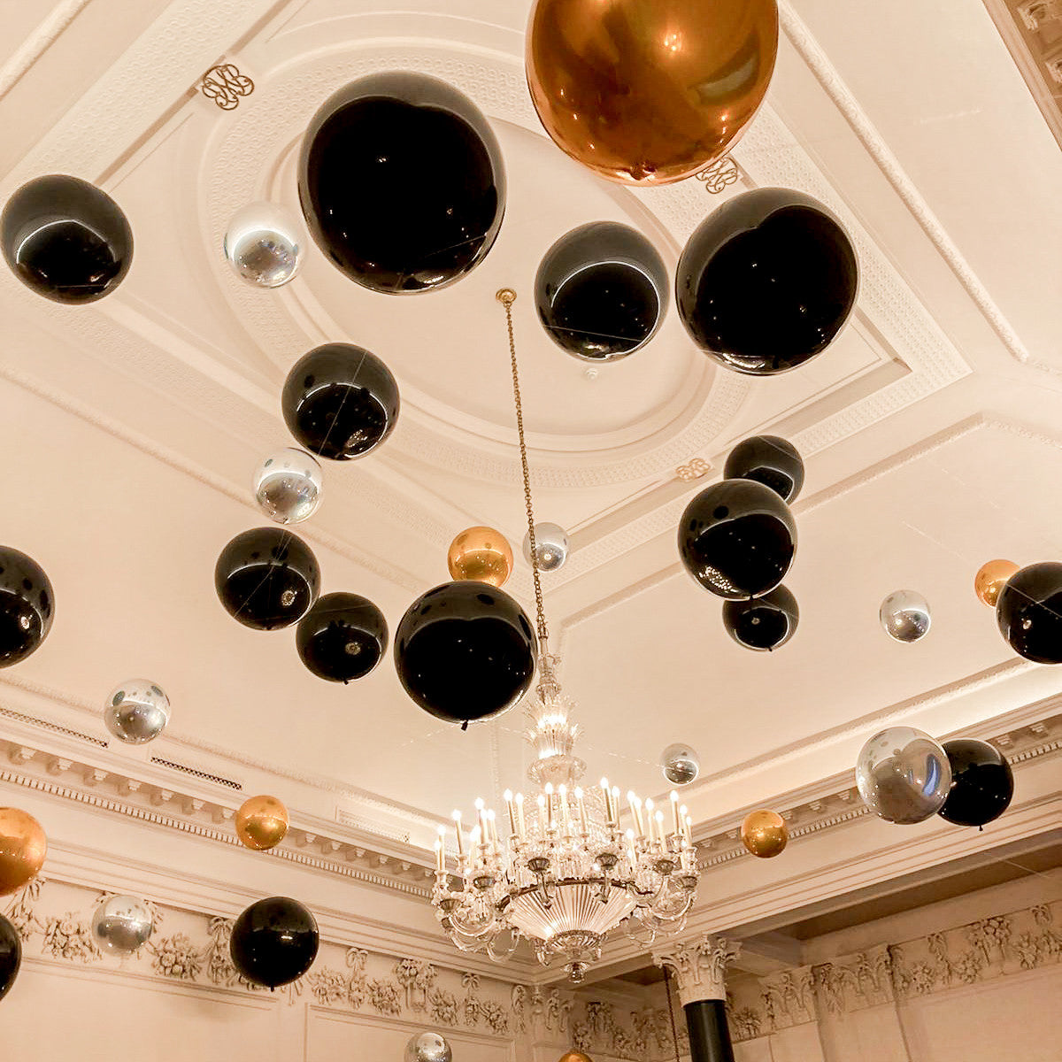 Suspended Floating Balloon Installation with giant and orbz balloons in a stunning event venue.