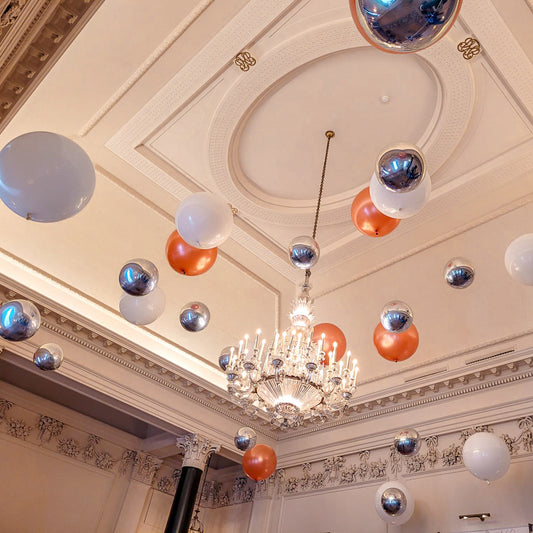 Suspended Floating Balloon Installation with giant and orbz balloons in a stunning event venue.