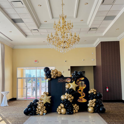 Elegant black and gold balloon backdrop with metallic star balloons for corporate gala in Toronto.