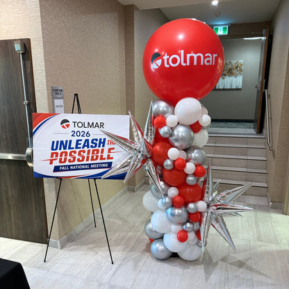 Red, white and silver corporate balloon column with a large Tolmar logo balloon and silver starbursts by Wooow Balloons in Toronto.
