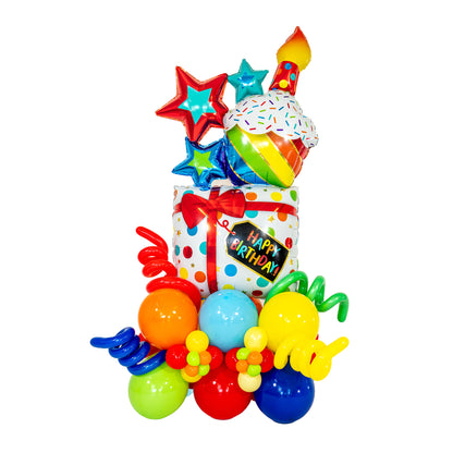 Cupcake birthday balloons with rainbow colours, foil stars, a Happy Birthday gift box and curled balloon accents by Wooow Balloons in Toronto