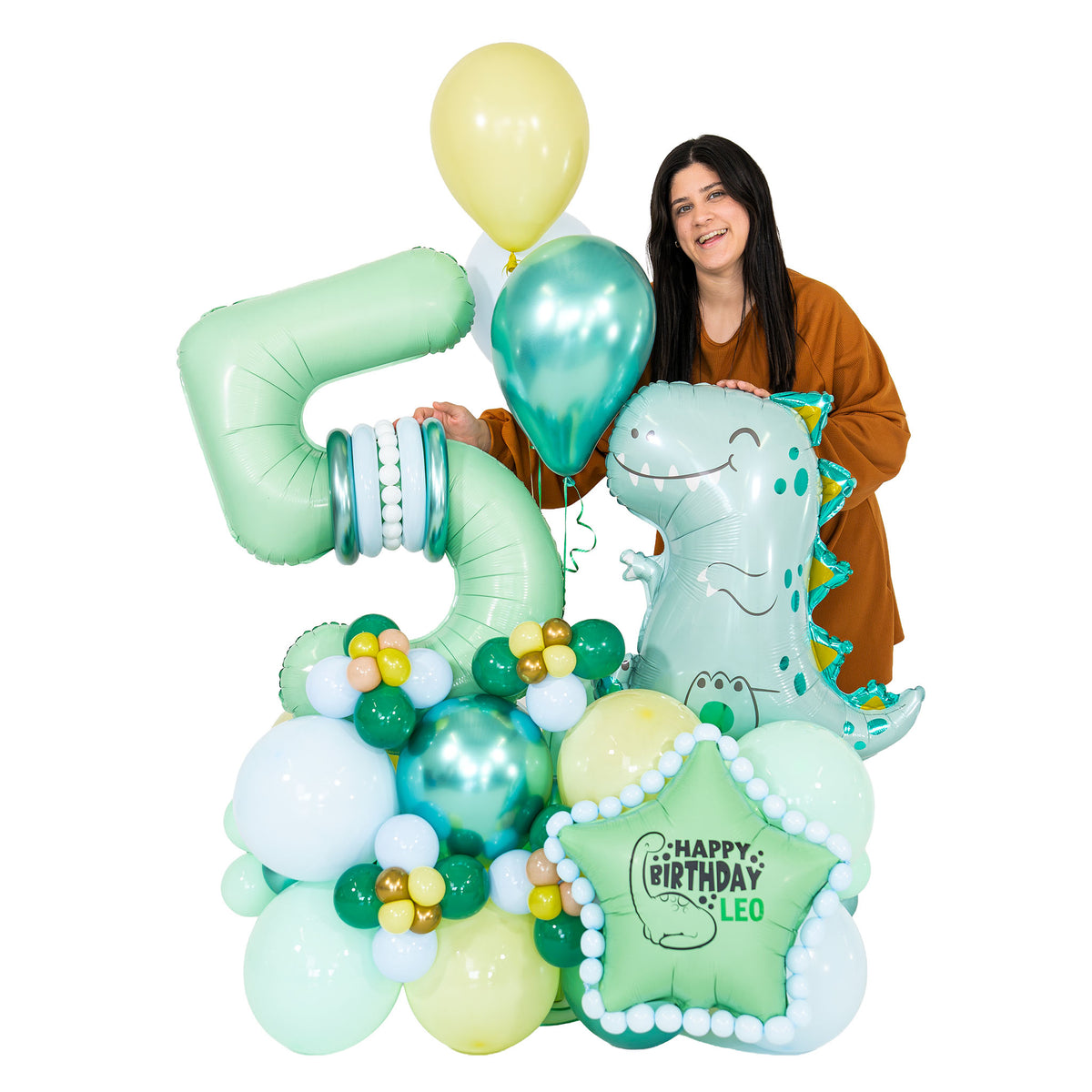 Woman standing behind a dinosaur birthday balloon arrangement with a large number 5, teal and pastel balloons, and personalized star