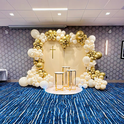 Decorative setup with balloons and a cross on a blue carpeted floor.