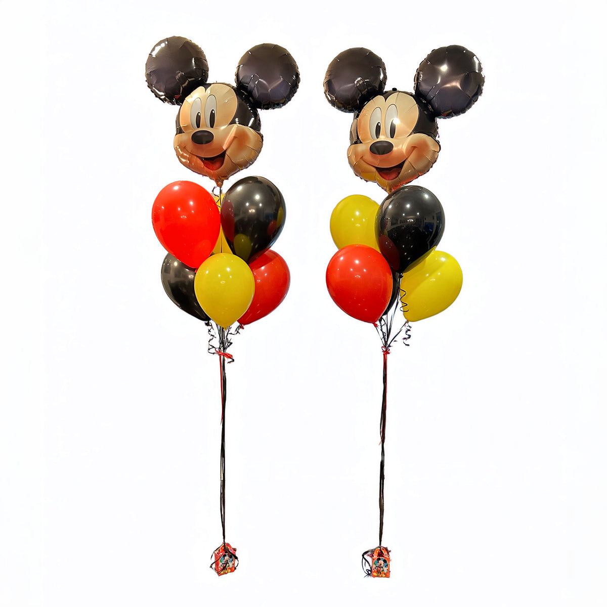 Full view of two Mickey Mouse birthday balloon bouquets on weighted stands