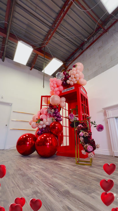 Valentine’s Day Telephone Photo Booth Backdrop Toronto featuring red balloon installation, florals, and statement metallic balloons