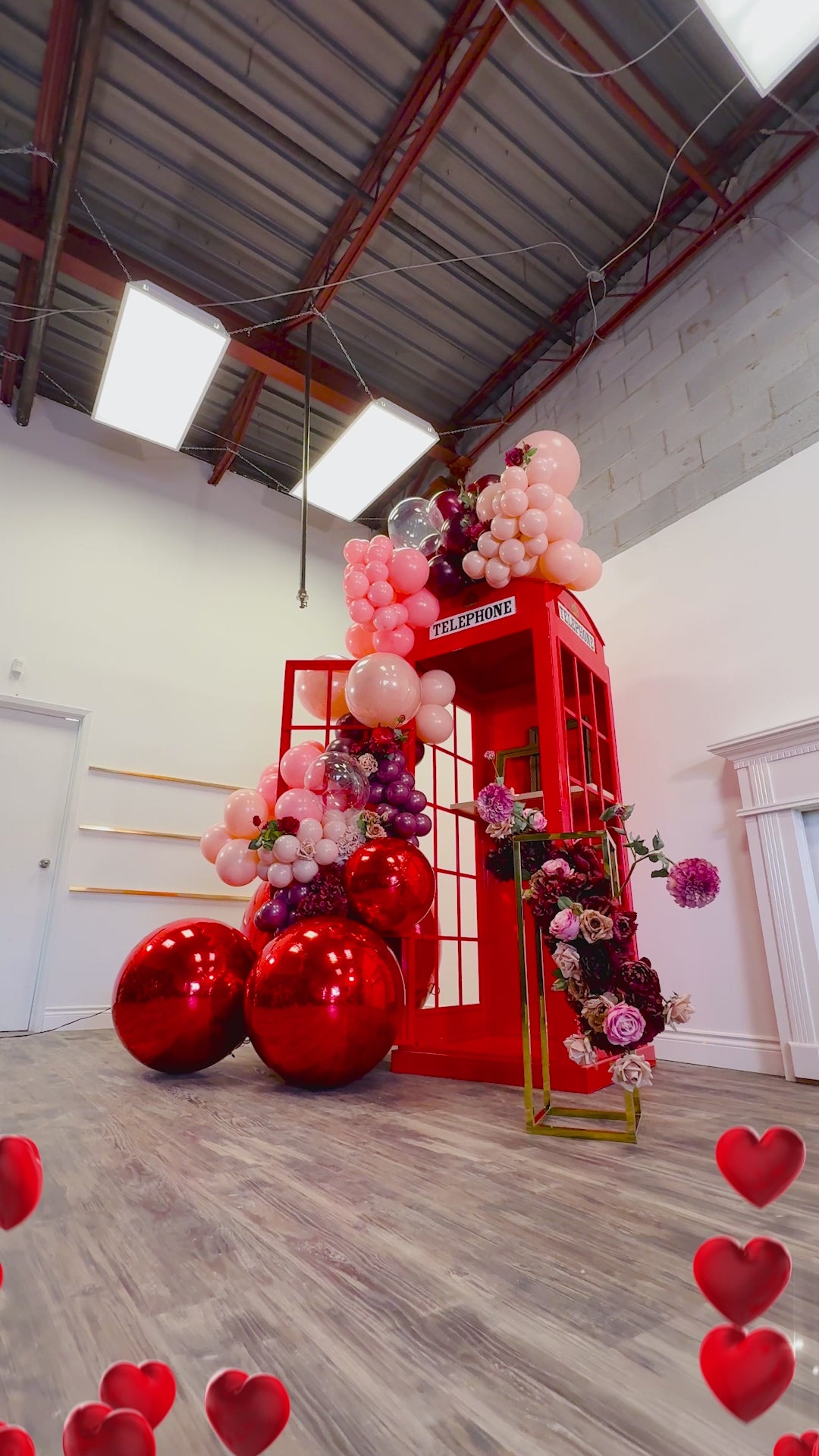 Valentine’s Day Telephone Photo Booth Backdrop Toronto featuring red balloon installation, florals, and statement metallic balloons