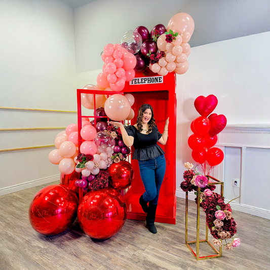 Telephone Photo Booth Backdrop Toronto with luxury red balloon garland and oversized metallic balloons for Valentine’s Day photos